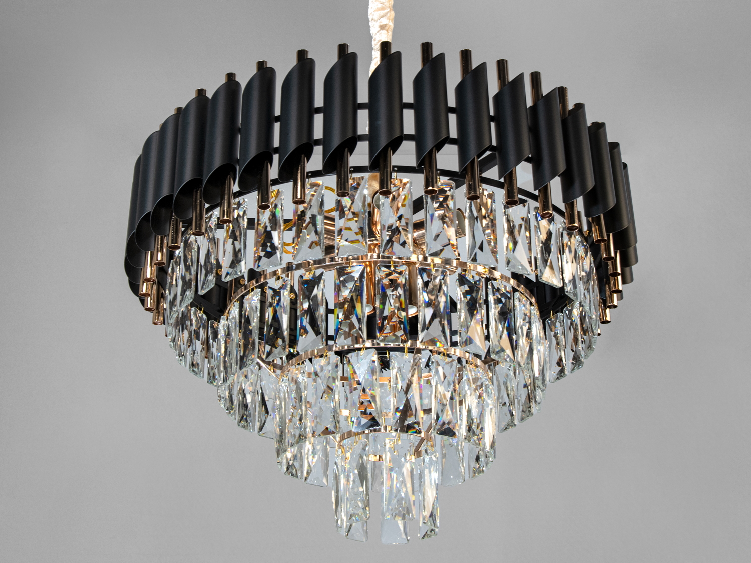 Кругла люстра з кришталевими підвісками та металевими деталями, створює ефектний світловий акцент у просторі.