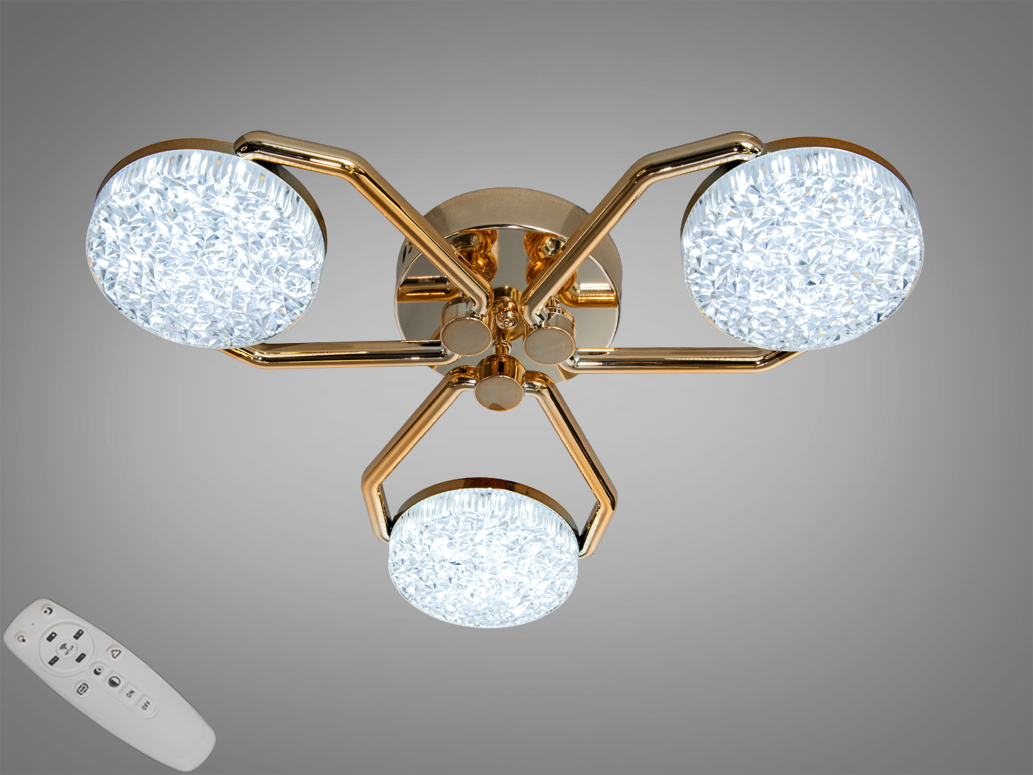 Стельовий світильник з трьома круглими акриловими LED-плафонами на золотистих кронштейнах, оснащений пультом дистанційного керування.
