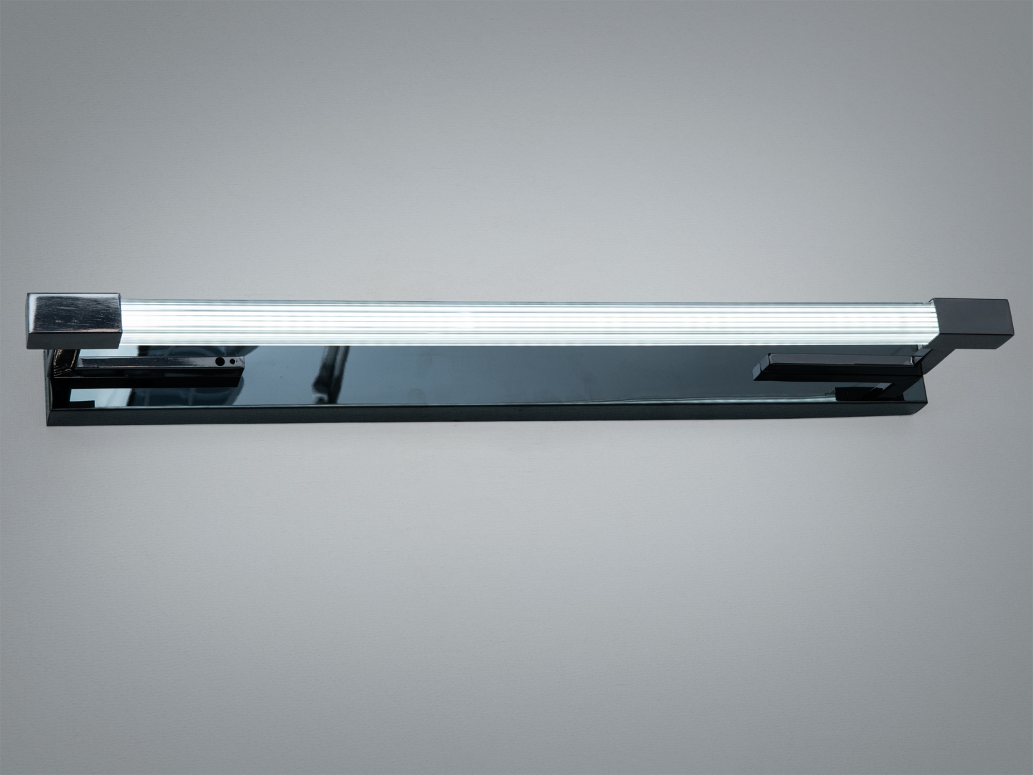 Настінний світильник з металевим корпусом, прямокутна форма. Призначений для ванної кімнати, забезпечує яскраве освітлення.