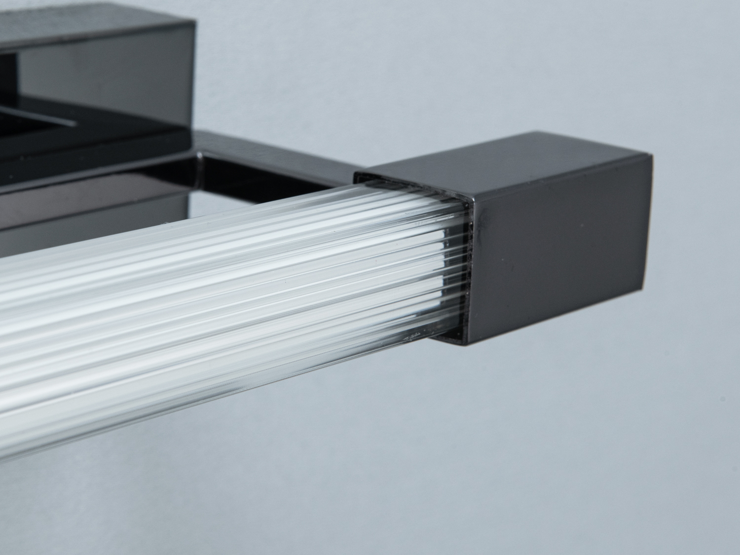 Близький вид на світильник з прозорим скляним розсіювачем світла, що підкреслює його текстуру.