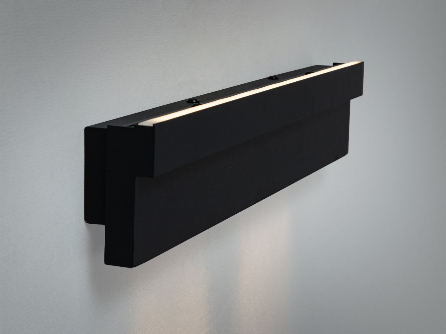Чорний світильник з боковим видом, що підкреслює його тонкий профіль. Випромінює світло зверху і знизу, ідеальний для вузьких коридорів.