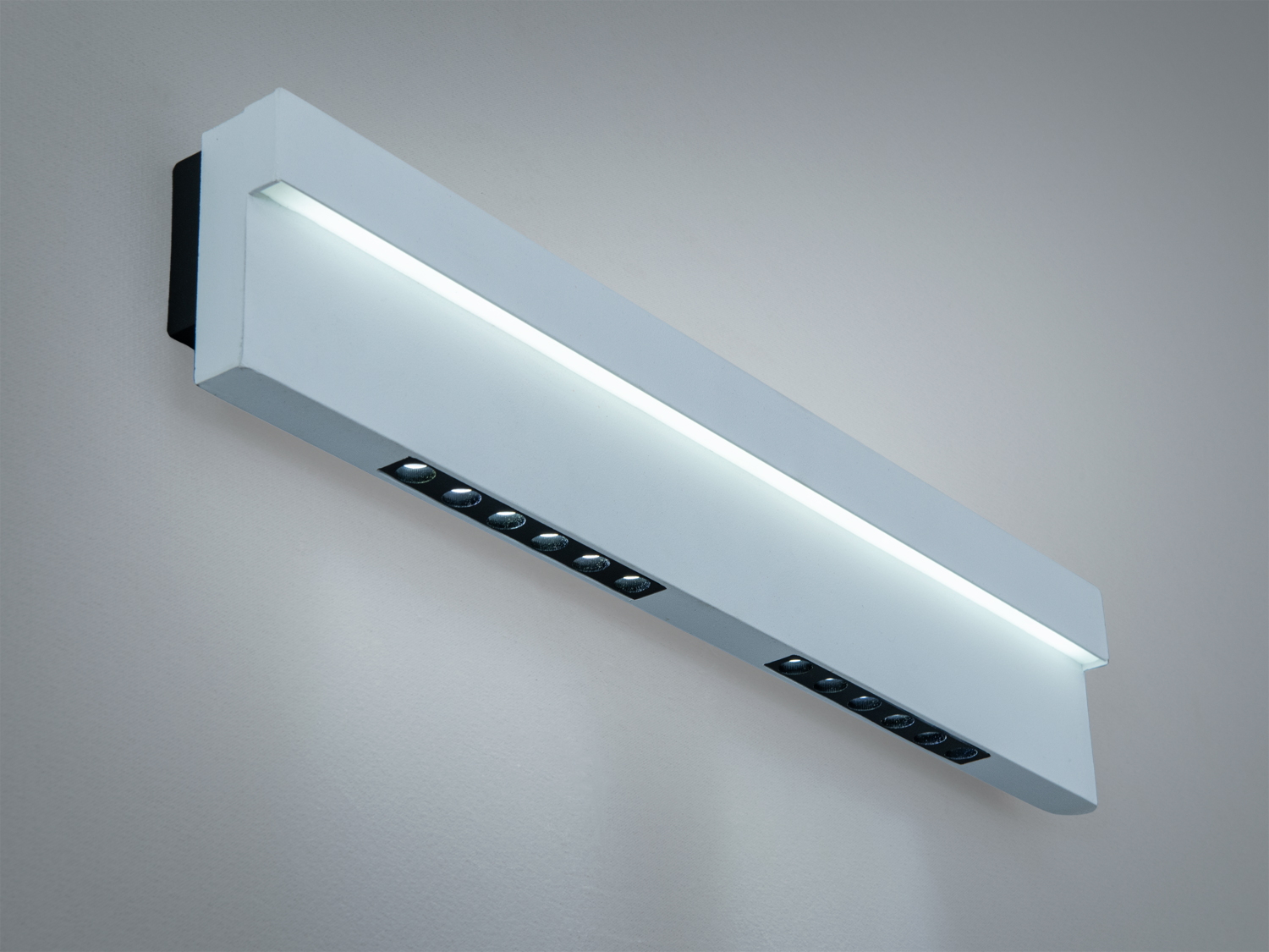 Настінний світильник з білим корпусом і вбудованими світлодіодами, що забезпечують спрямоване освітлення.