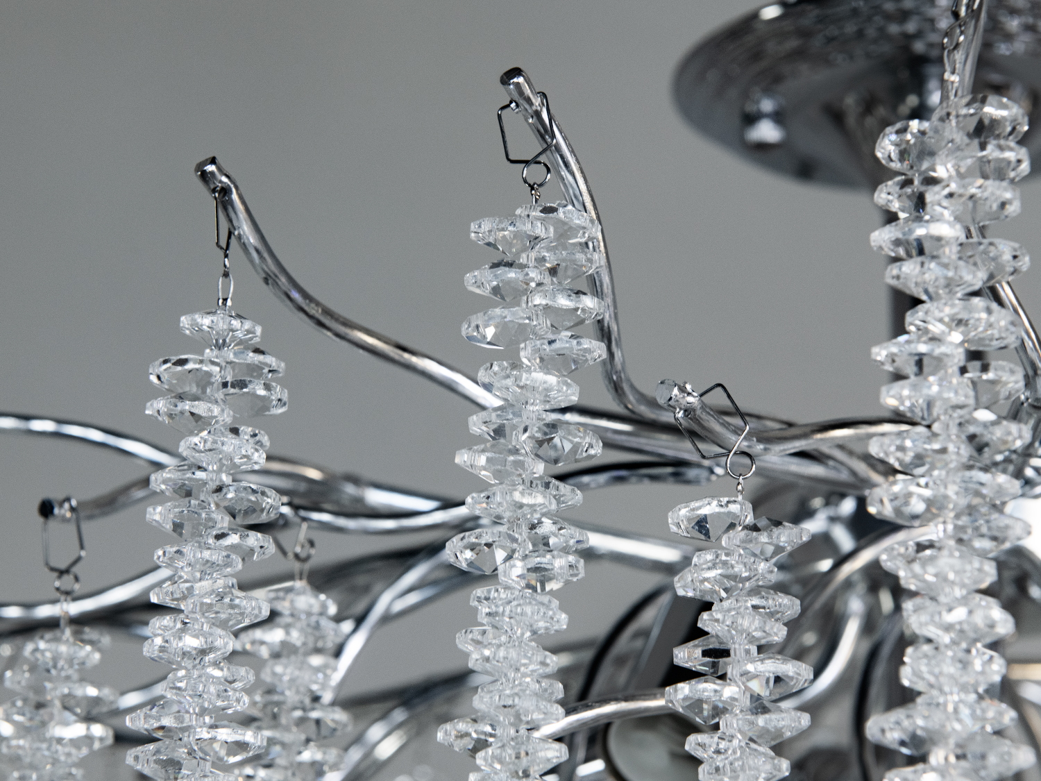 Детальний вигляд кришталевих підвісок на металевій основі люстри. Підвіски надійно закріплені, додаючи елегантності.