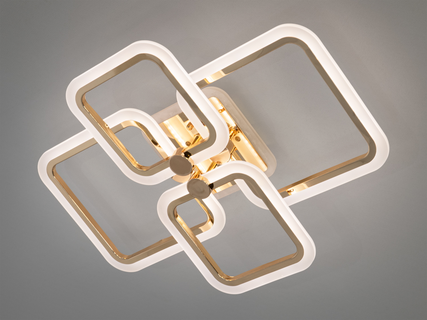Стельовий світильник з квадратними рамками, що переплітаються, з золотистими акцентами, підходить для сучасного інтер’єру.