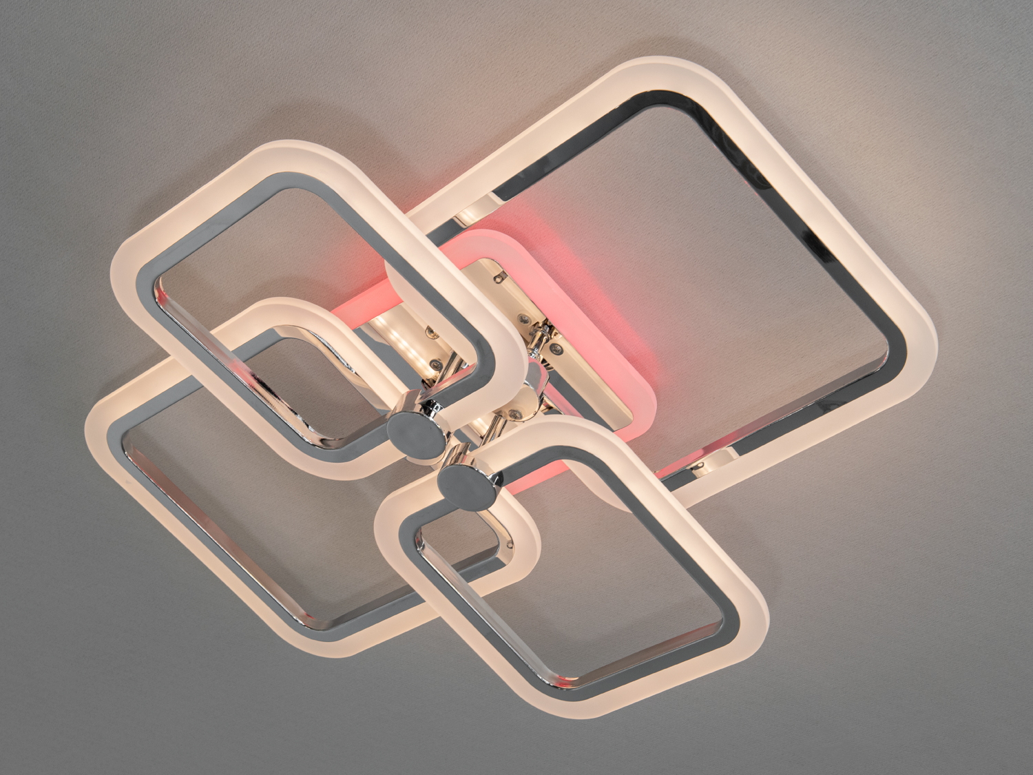 Світильник з чотирма квадратними рамками, що випромінюють м`яке рожеве світло, підходить для сучасного інтер`єру.