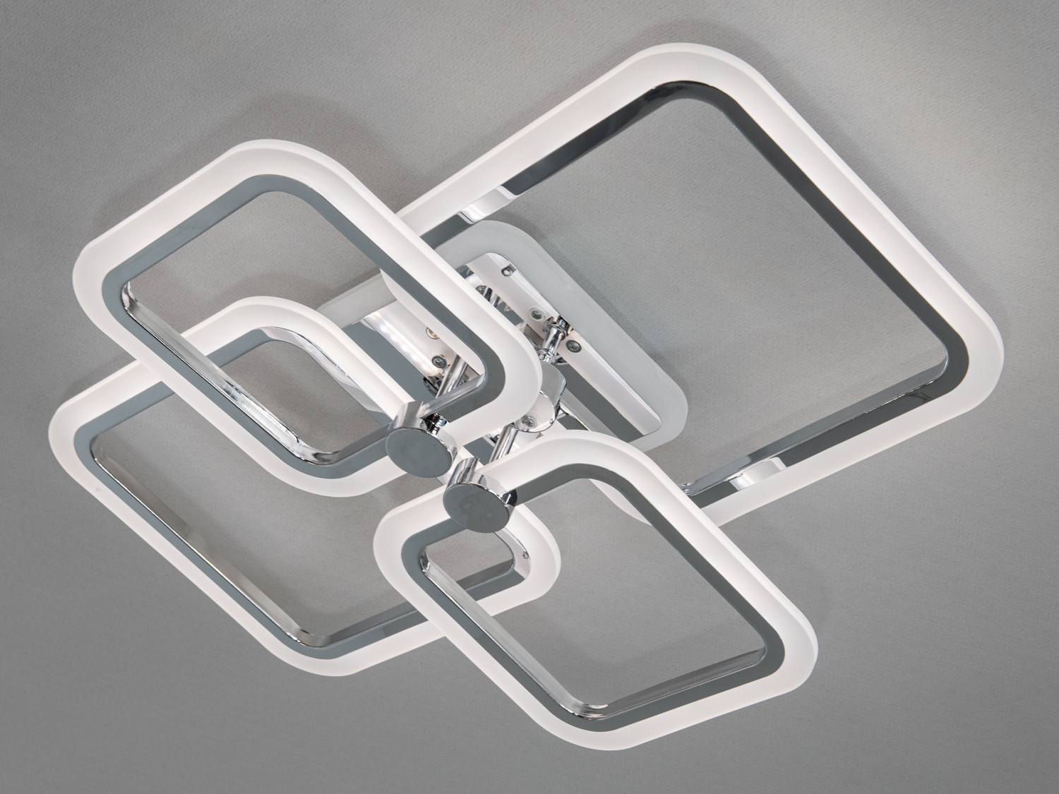 Стельовий світильник з хромованими квадратними рамками, що випромінює біле світло, ідеальний для офісних приміщень.