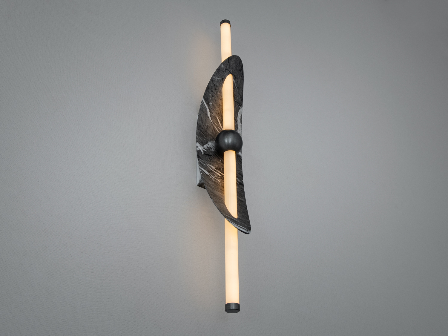 Настінний світильник з мармуровою пластиною та вертикальними трубками, що випромінюють тепле світло. Ідеально для затишних просторів.