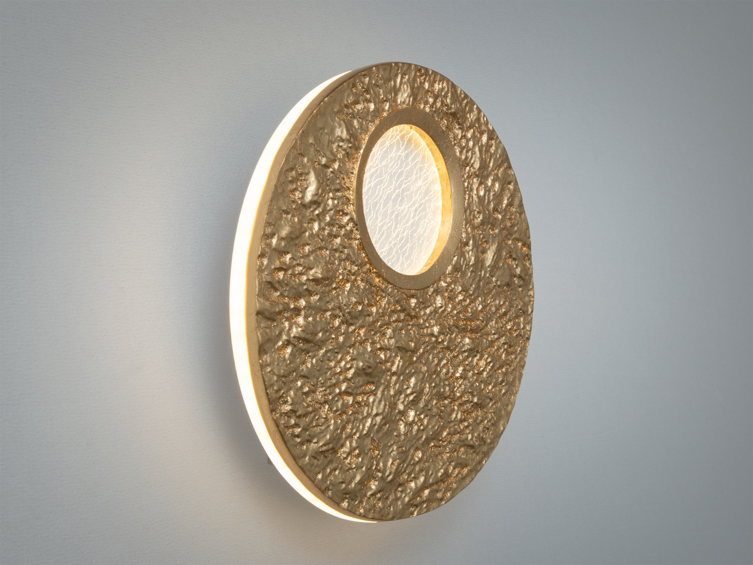 Бічний вигляд настінного світильника з рельєфною текстурою. Основа світильника має круглу форму з прозорим склом для м’якого освітлення.