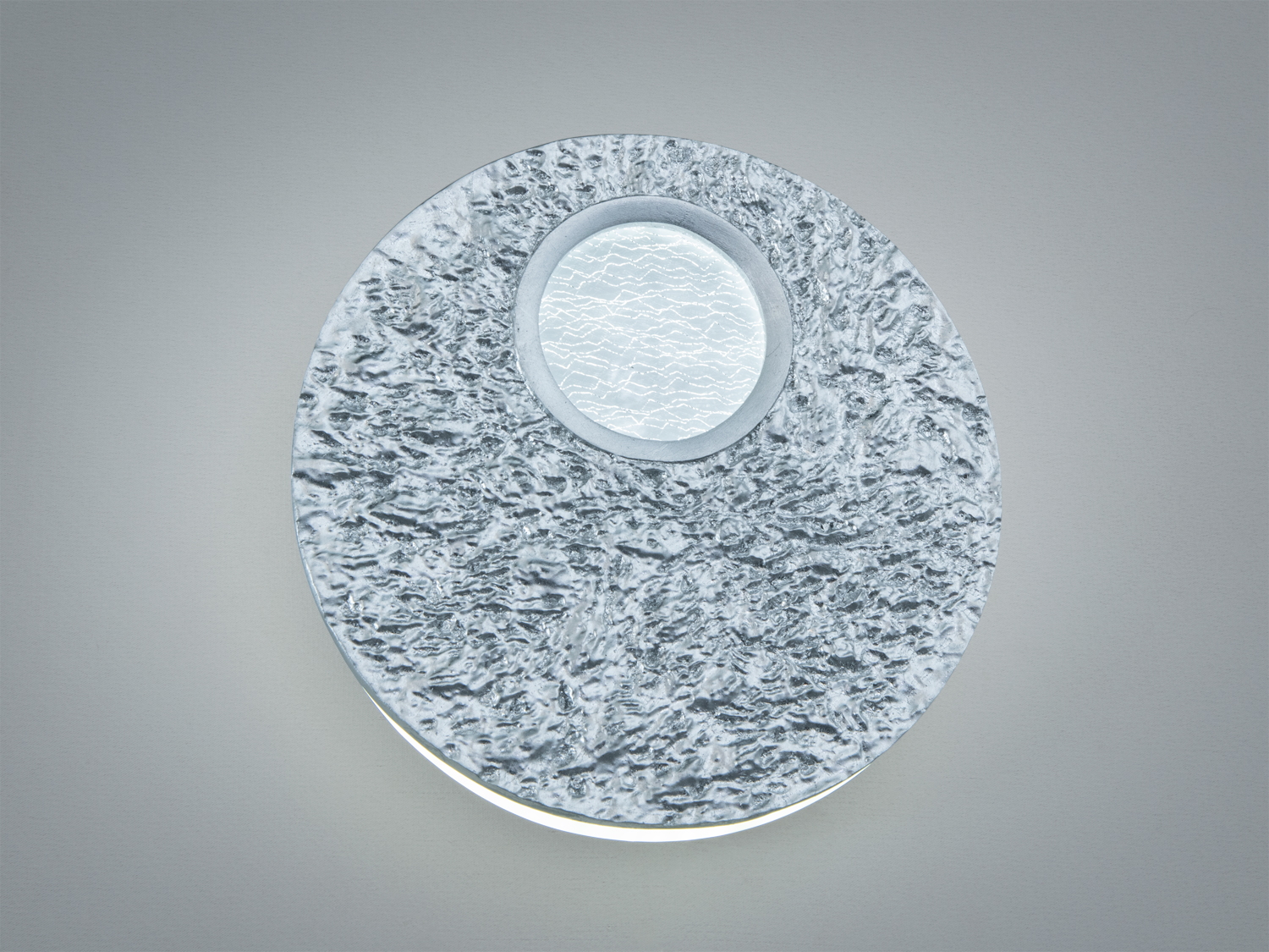 Круглий настінний світильник з текстурованим металевим покриттям, центральне скло з візерунком.