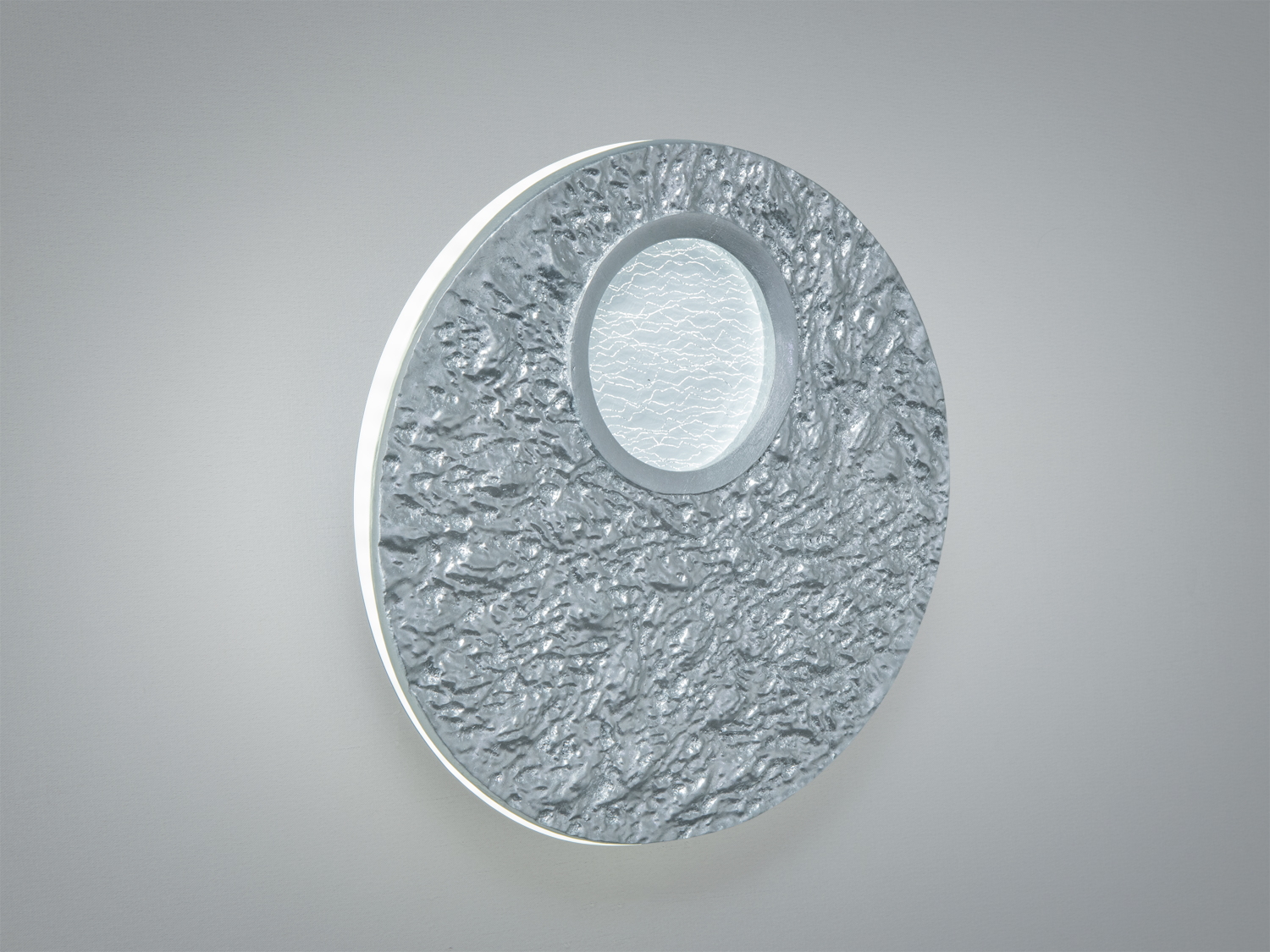 Настінний світильник з рельєфною металевою поверхнею, центральний елемент з матового скла.