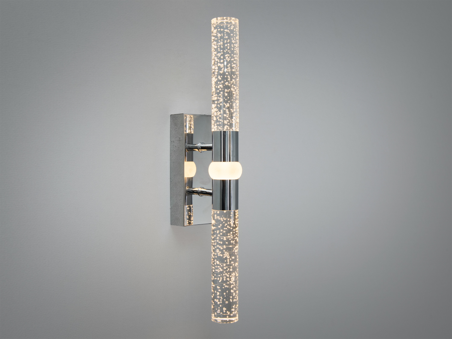 Світильник з вертикальними трубками, що випромінюють тепле світло, закріплений на стіні. Підходить для ванної кімнати.