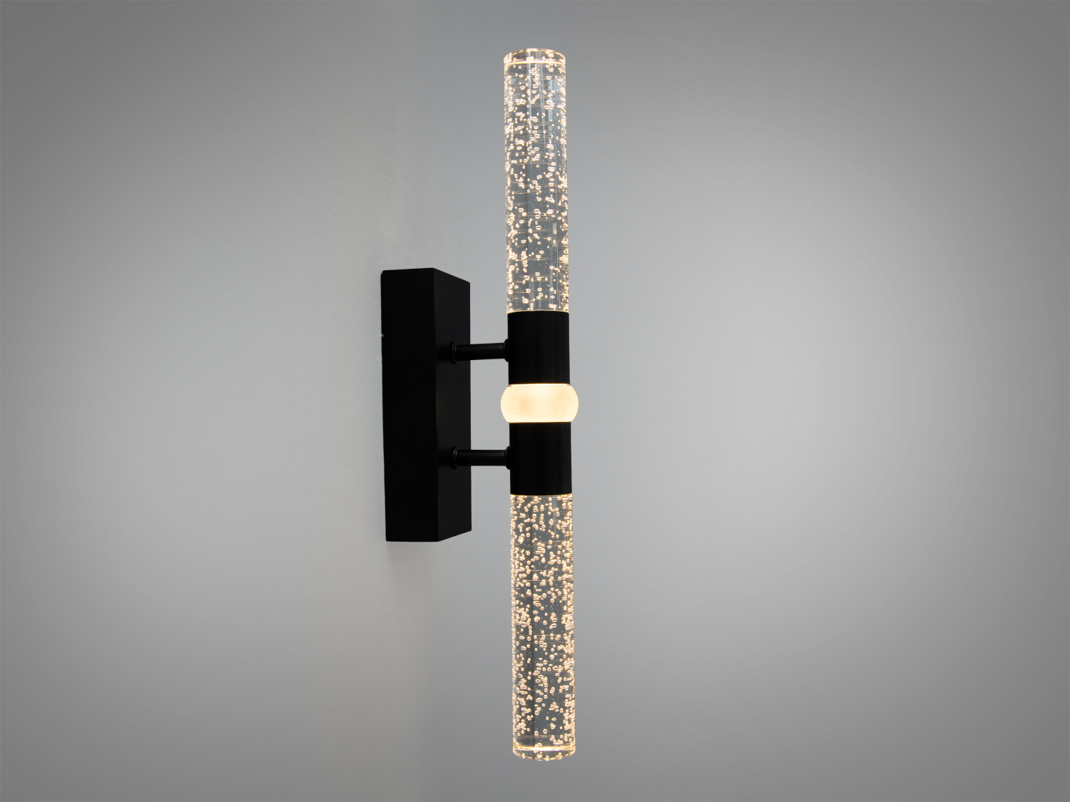 Настінний світильник з чорним кріпленням, прозорі трубки з бульбашками, підсвічування теплого тону, підходить для затишних просторів.