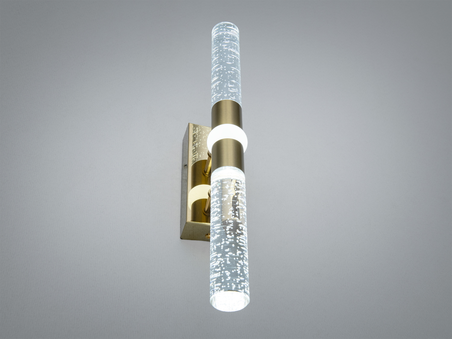 Світильник з металевим кріпленням та скляним плафоном, що випромінює м’яке світло, підходить для настінного монтажу у вітальні.