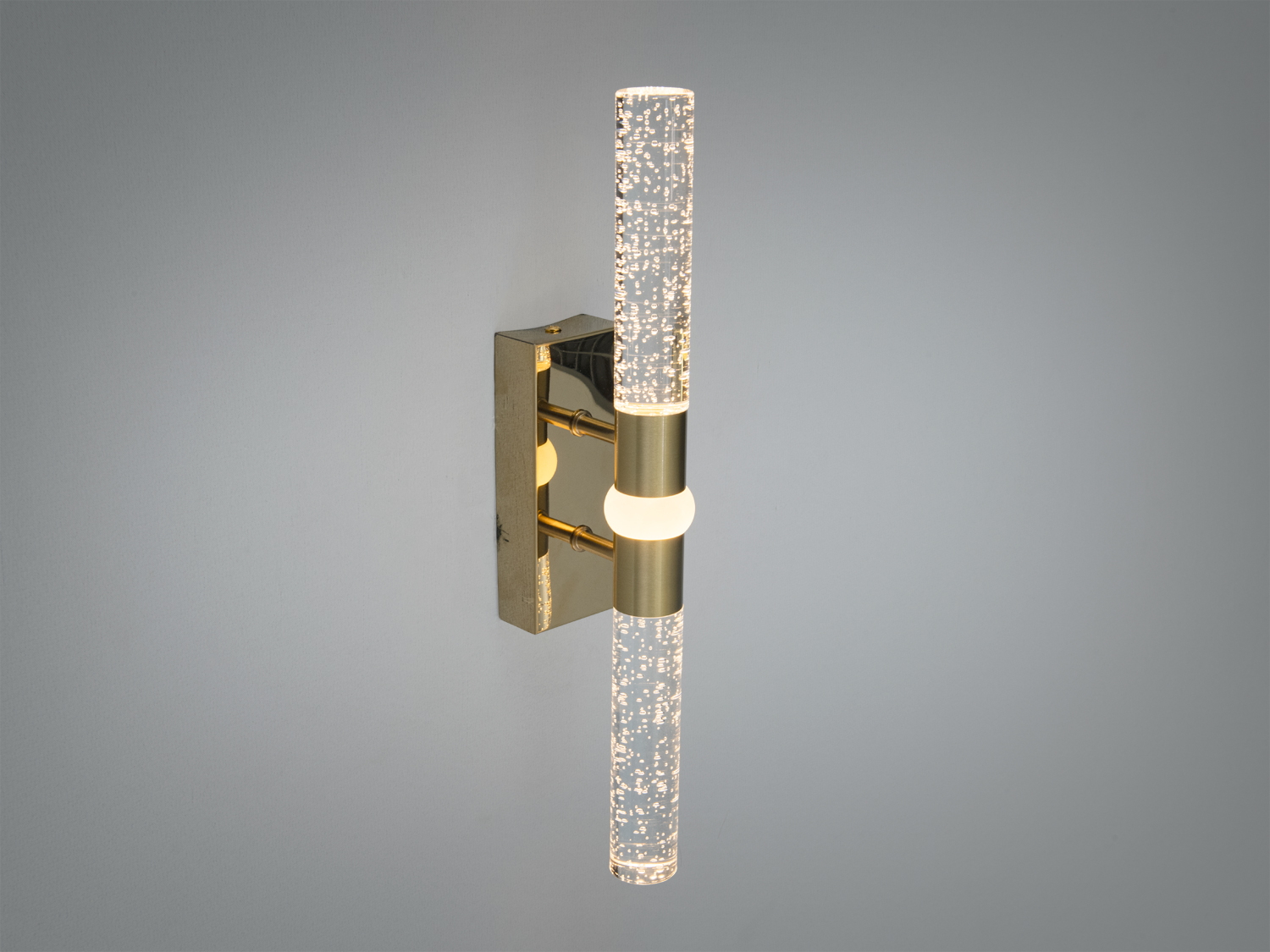 Настінний світильник з вертикальним розташуванням, має металеву основу та скляний плафон з ефектом бульбашок, ідеальний для ванної кімнати.