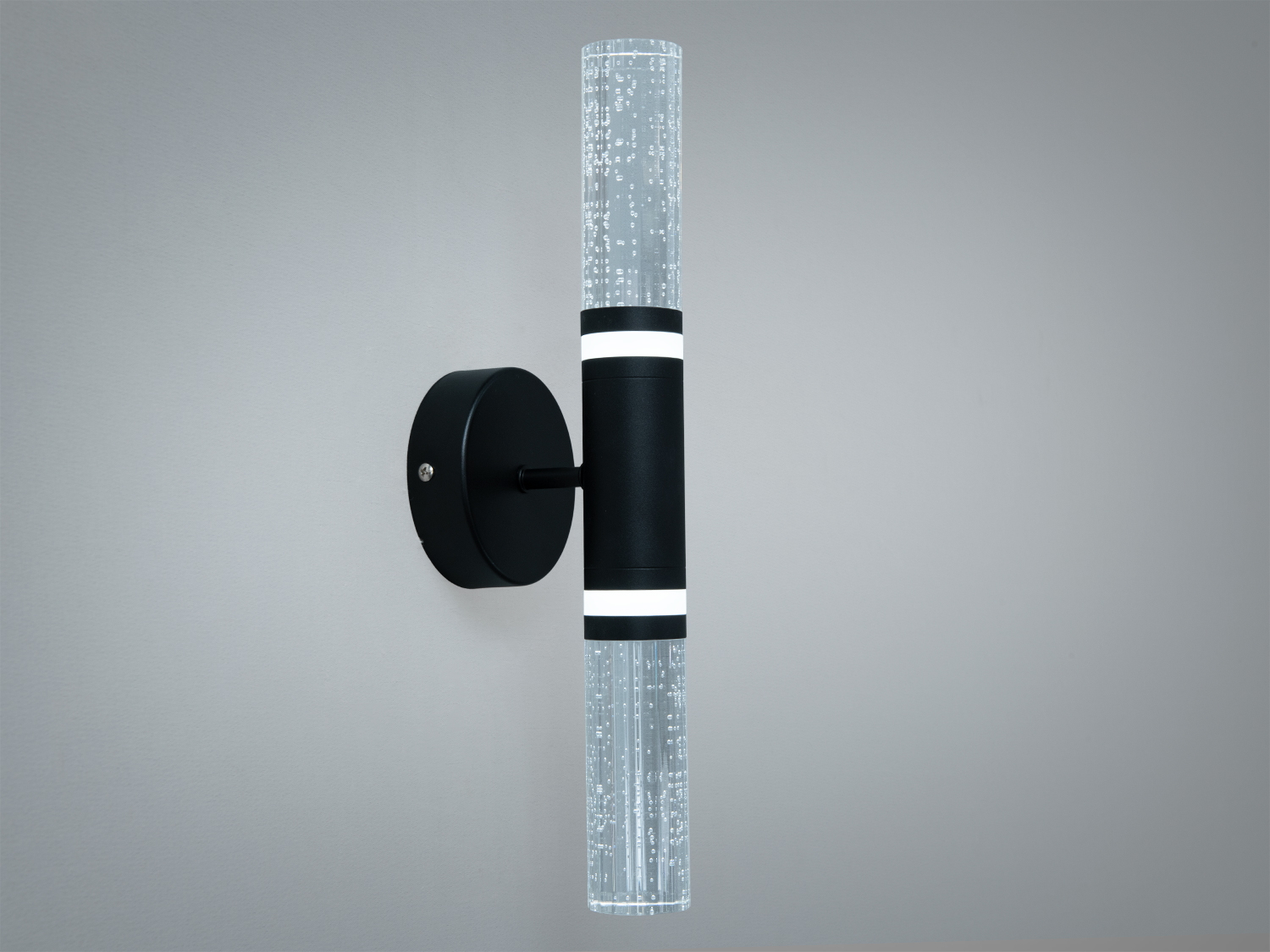 Настінний світильник з прозорим плафоном, що має бульбашковий візерунок. Чорна основа, ідеальний для освітлення коридорів.