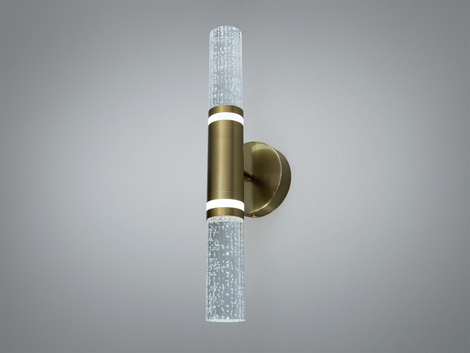 Вертикальний настінний світильник з двома скляними циліндрами, розташованими по обидва боки металевого корпусу. Призначений для сучасних інтер’єрів.