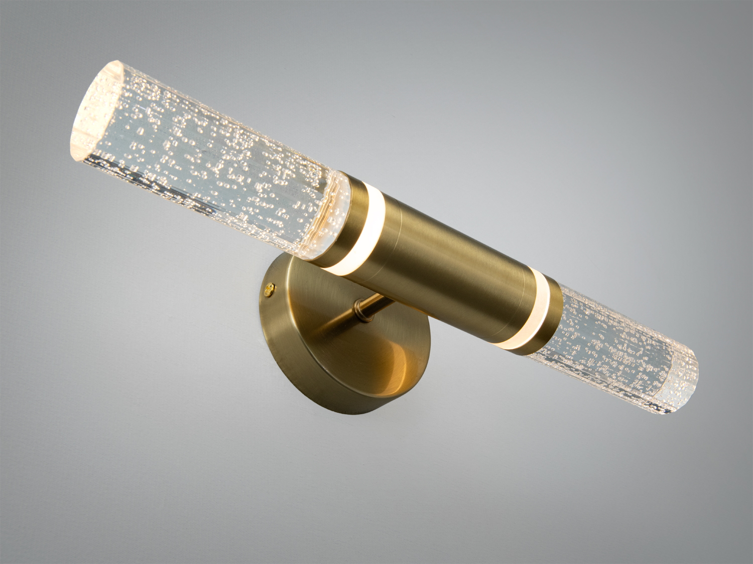 Похилий настінний світильник з металевим корпусом і скляними циліндрами, що створюють акцентне освітлення. Підходить для ванних кімнат.