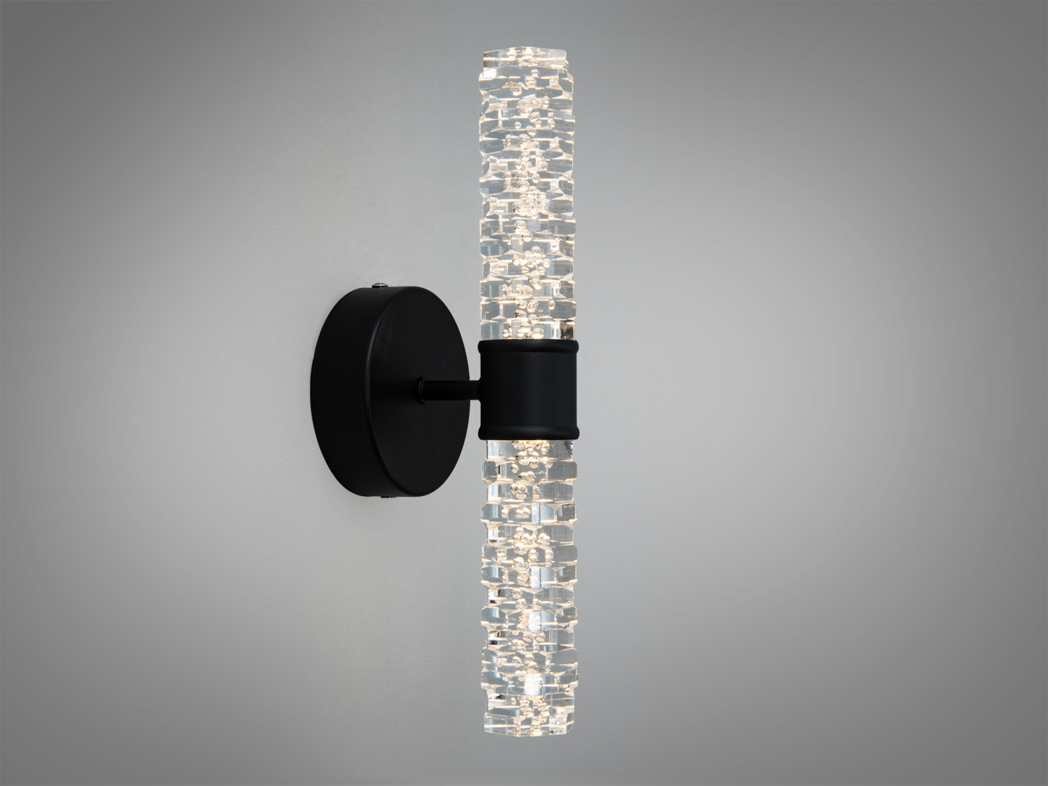 Декоративний світильник з трубчастим плафоном, що кріпиться на чорній основі, підходить для сучасного інтер’єру.