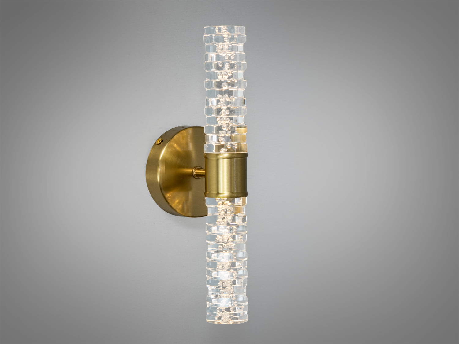 Настінний світильник з латуні та прозорого скла, що випромінює тепле світло. Підходить для спалень.