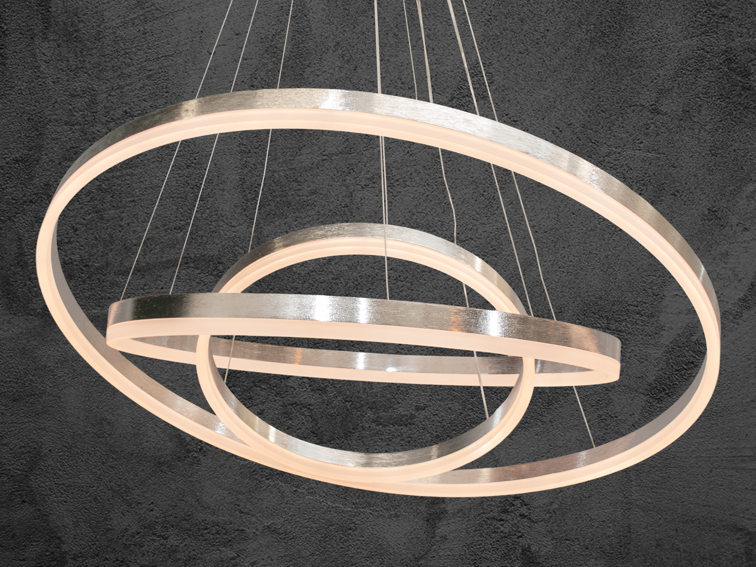 Світильник з теплим світлом, що випромінюється з трьох металевих кілець, ідеально підходить для вітальні.