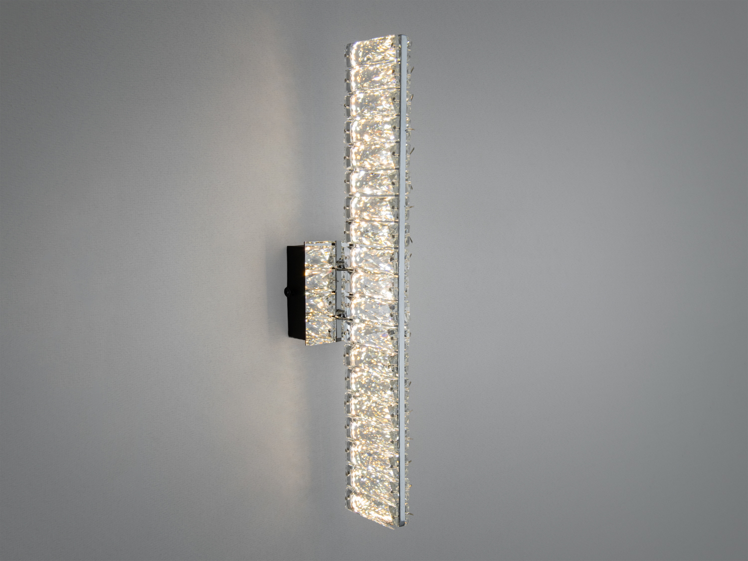 Настінний світильник із довгою кришталевою панеллю, що створює ефектний світловий акцент, ідеальний для вітальні.