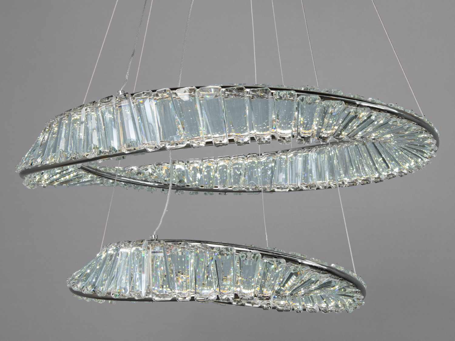 Декоративна люстра з кришталевими елементами у формі кілець. Підвісна конструкція підходить для високих стель.