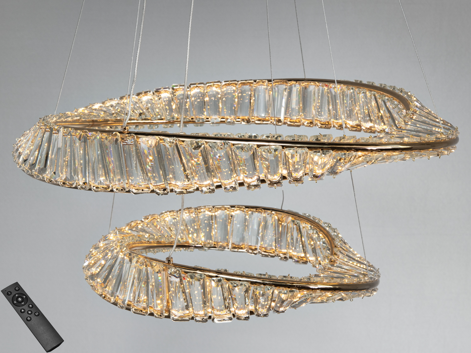 Люстра з двома кришталевими кільцями, підвішена на тонких тросах, створює ефект легкості в сучасному інтер’єрі.