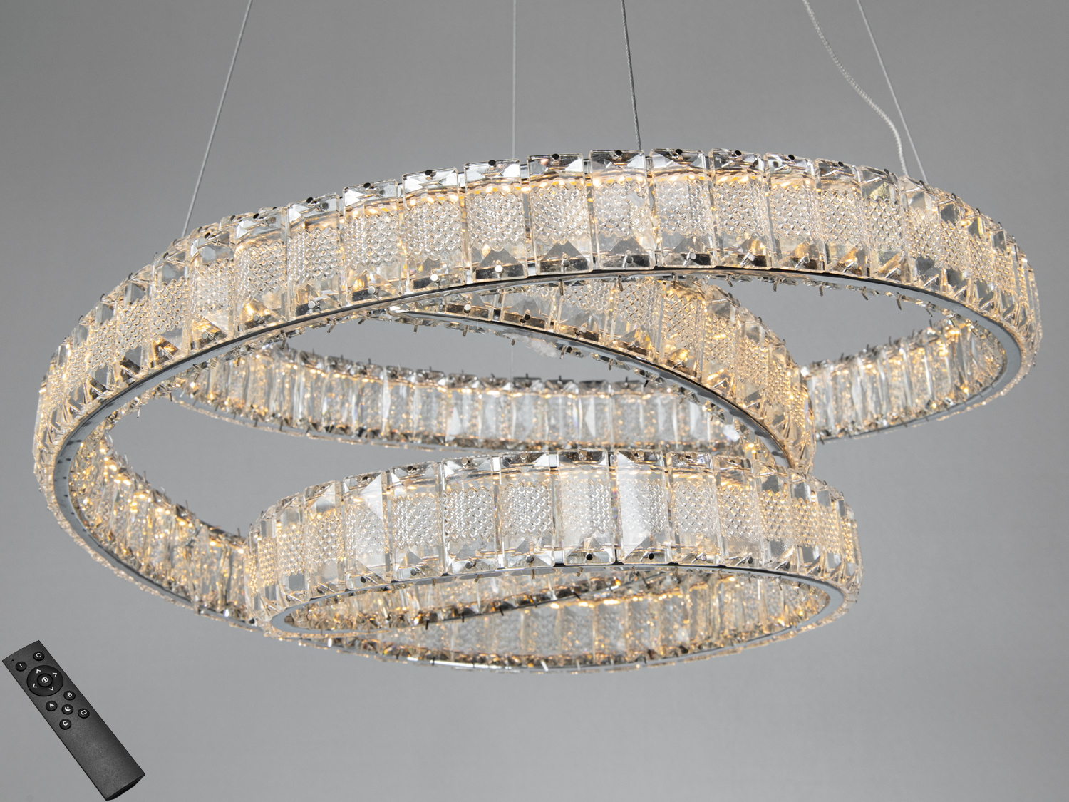 Люстра з двома кільцями, оснащена пультом дистанційного керування, що дозволяє регулювати яскравість освітлення.