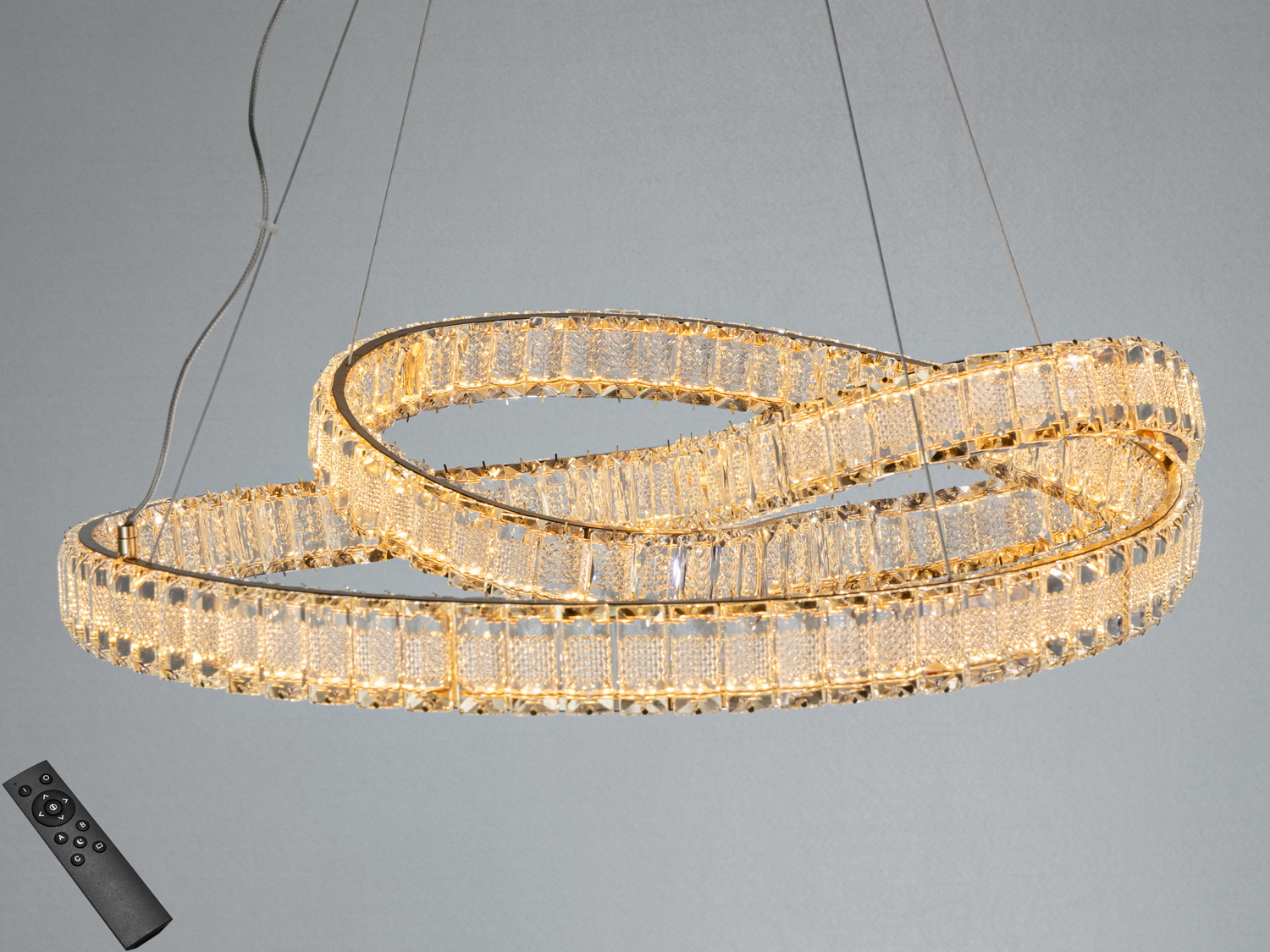 Люстра з дистанційним управлінням, має переплетені кільця з металу та скла, забезпечує регульоване освітлення.