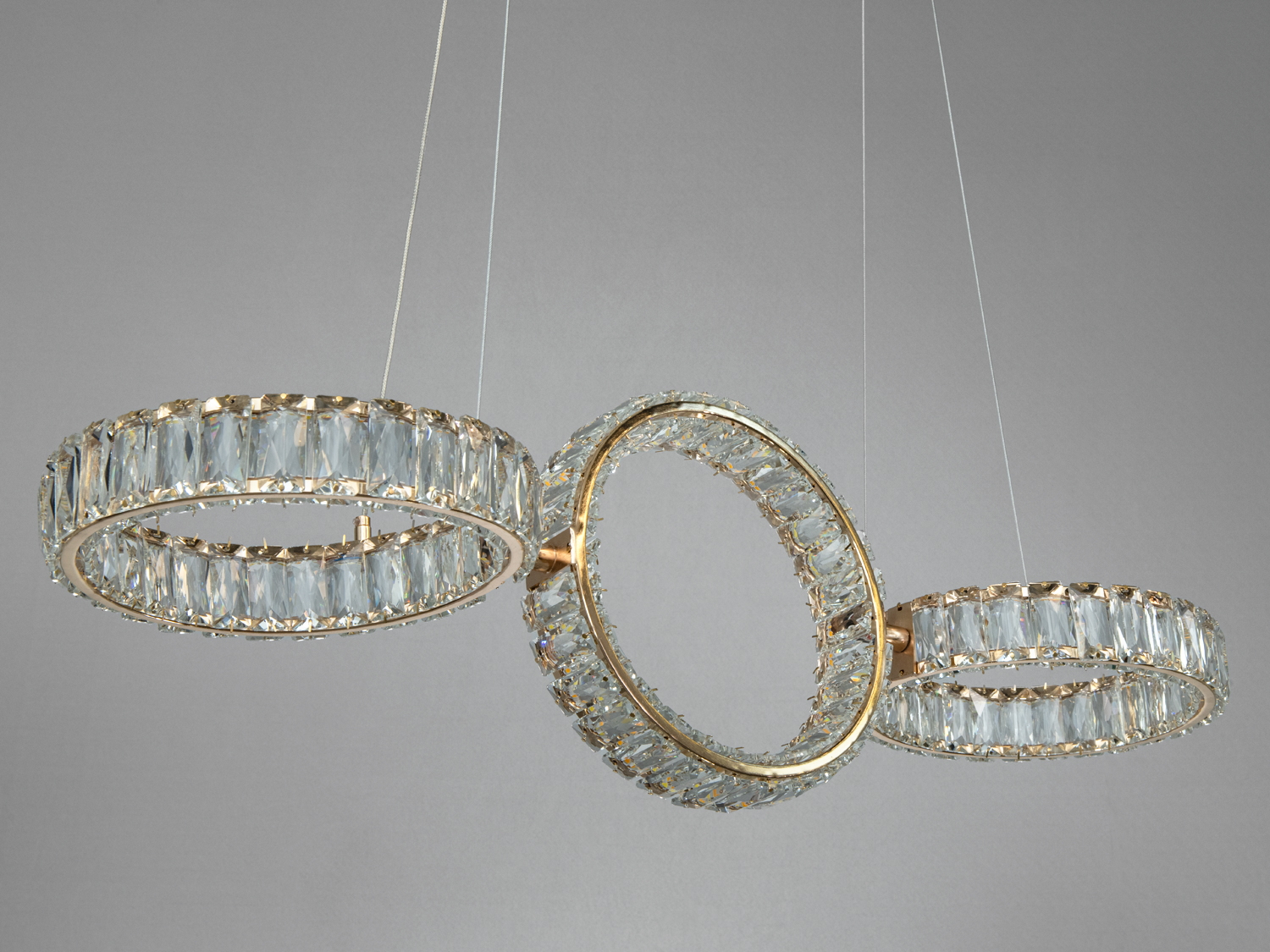 Три кільця з кришталю у підвісній люстрі, що створює ефектний світловий акцент. Підходить для високих стель.
