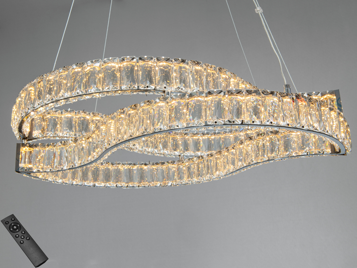 Підвісний світильник з пультом дистанційного керування, що дозволяє регулювати яскравість. Скляні елементи створюють хвилястий візерунок.