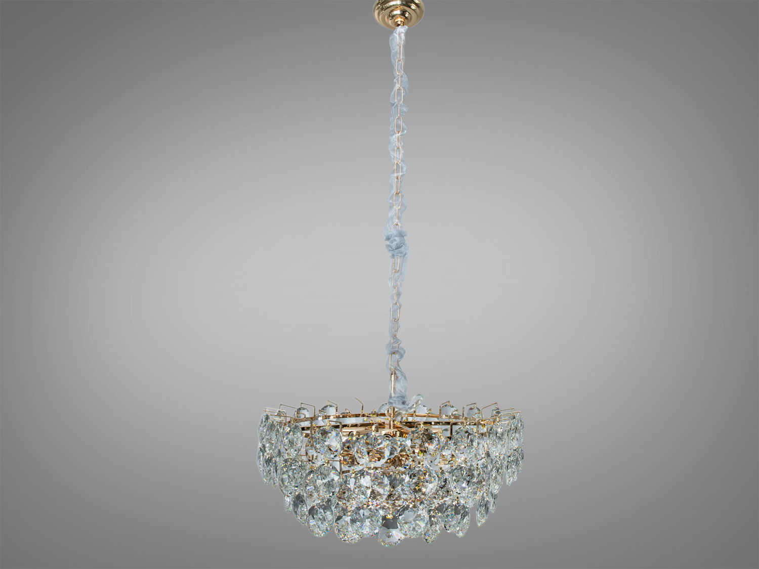 Підвісна кришталева люстра з витонченою формою, розрахована на монтаж у вітальні. Витий підвіс додає елегантності.