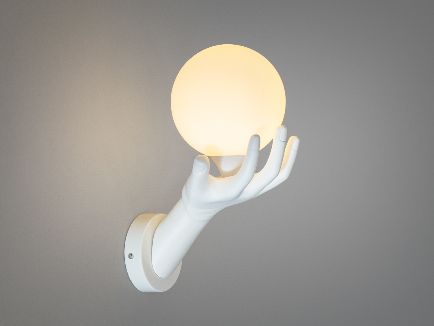 Унікальний настінний світильник у формі руки, що тримає кулю. Підходить для декоративного освітлення в сучасних просторах.