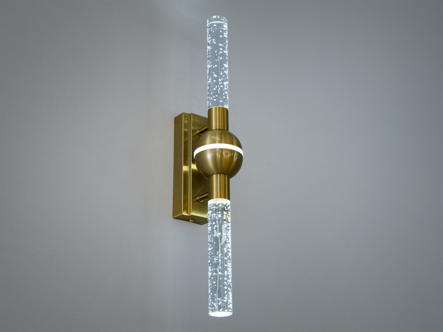 Світлодіодний світильник наче з шаром між двома плафонами світить теплим кольором світіння.