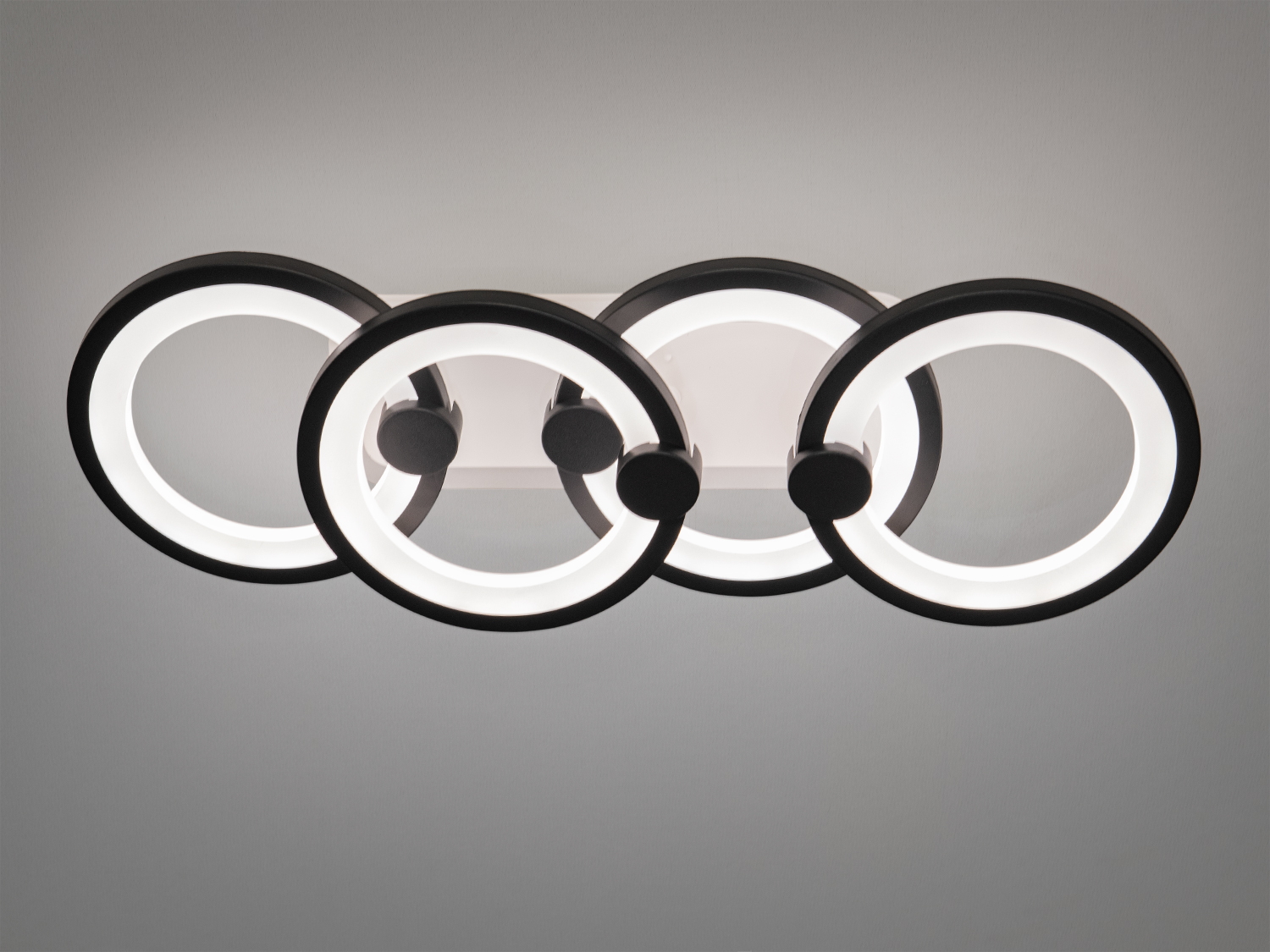 Стельовий світильник з чотирма кільцями, що випромінюють нейтральне світло. Ідеальний для офісних приміщень.