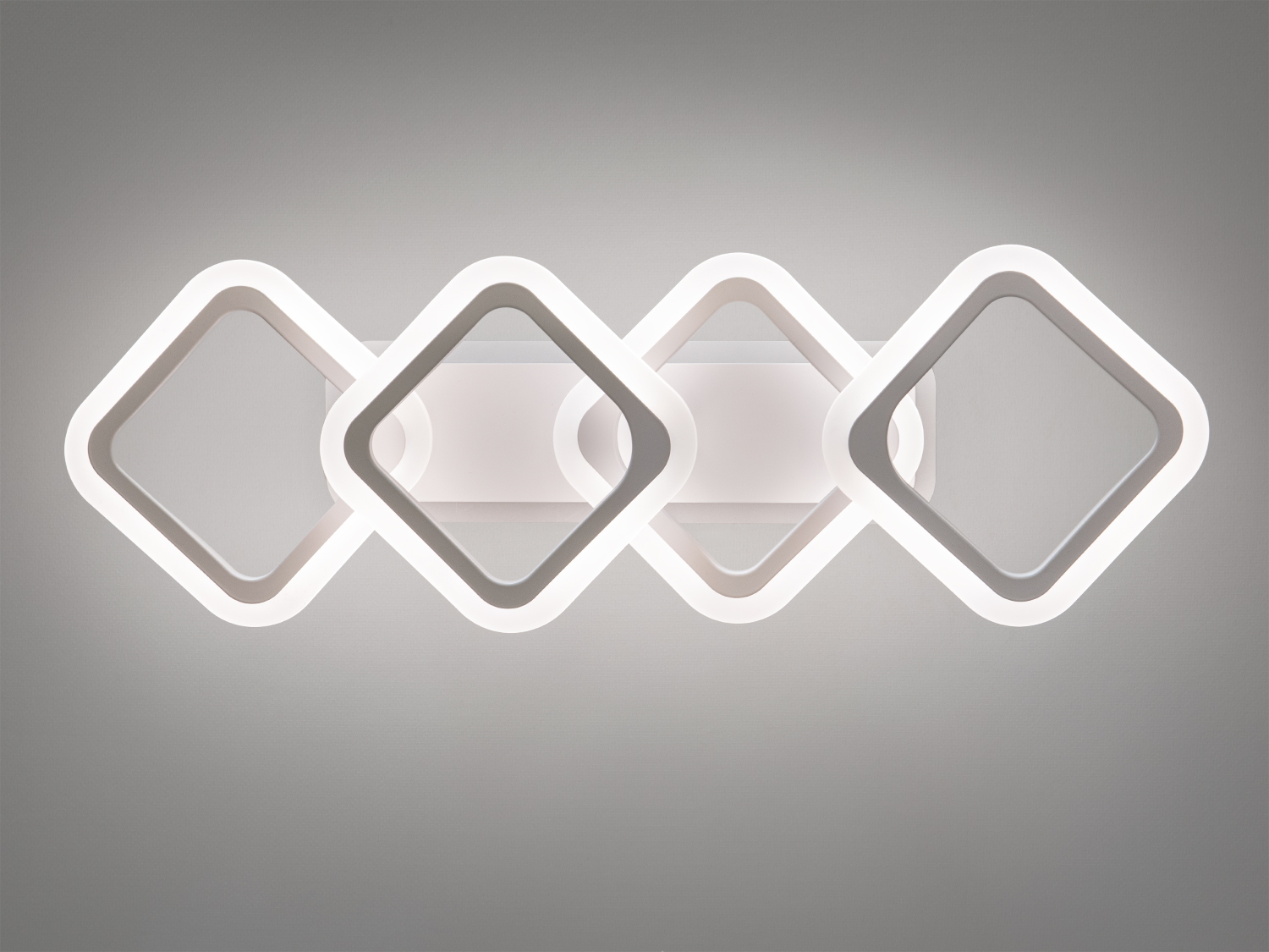 Білий настінний світильник з чотирма квадратними елементами, що підходить для мінімалістичного дизайну.