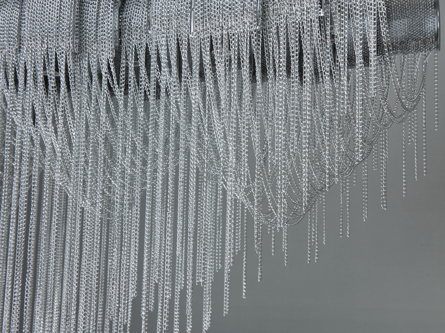 Гра світла на хромованих поверхнях ланцюгів створює магічні відблиски, додаючи приміщенню атмосферу вишуканості та драматичності.