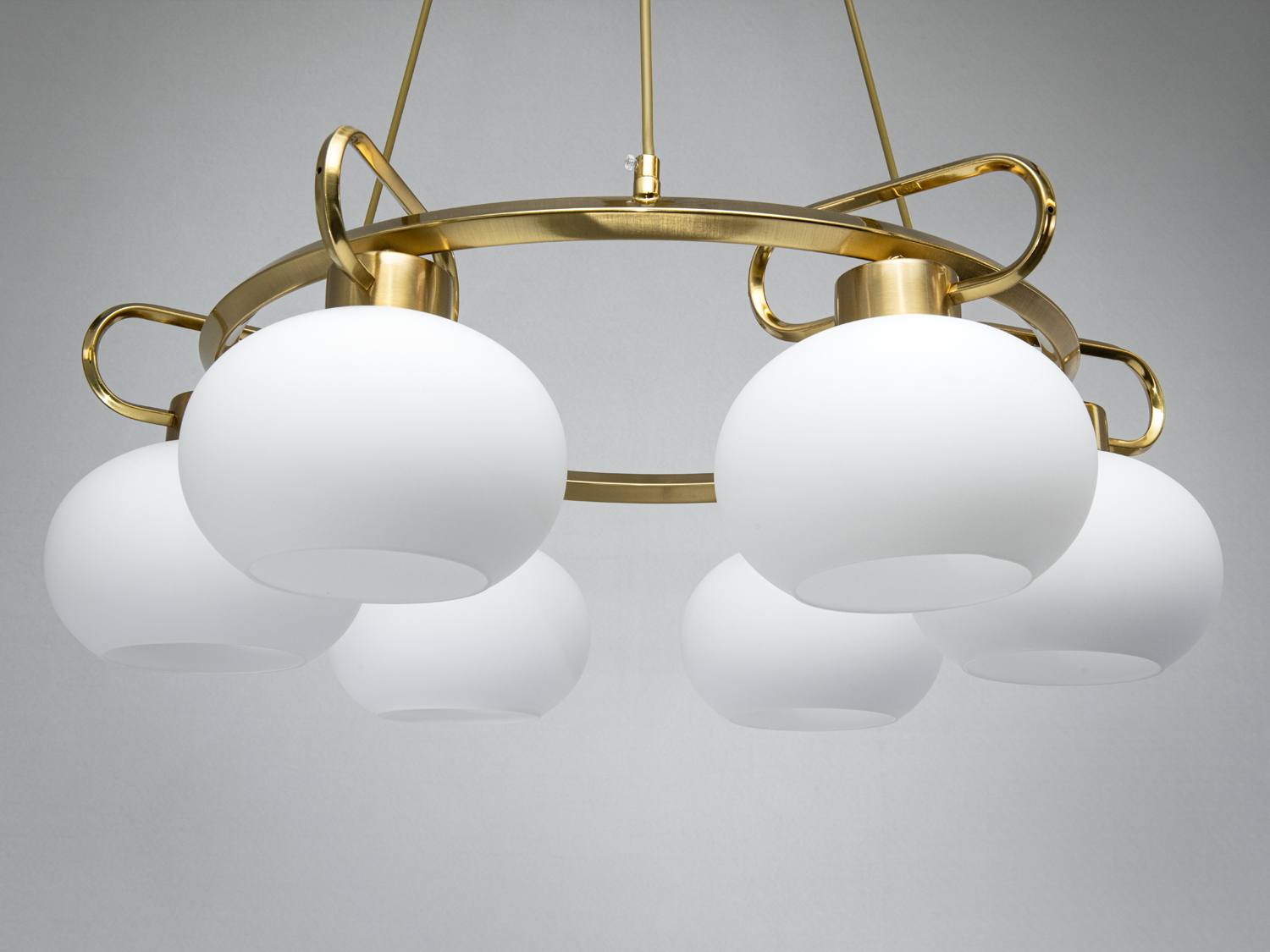 Люстра з шістьма матовими плафонами, розташованими на золотистому кільці. Призначена для центрального освітлення кімнати.