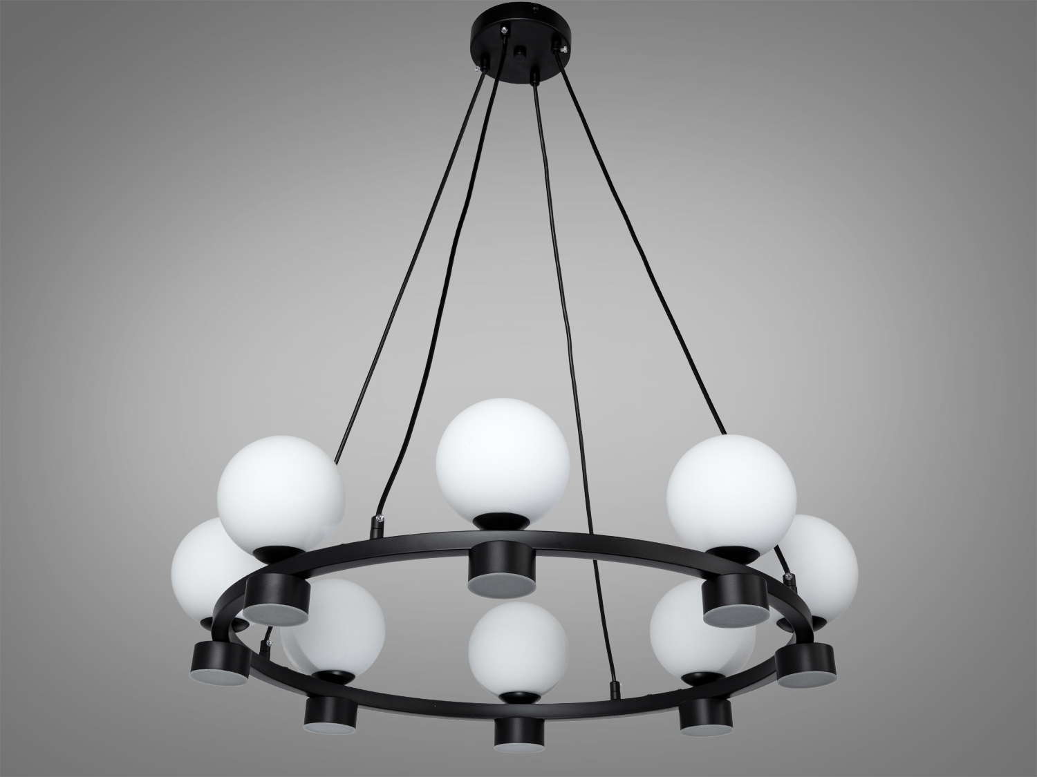 Підвісна люстра з чорним металевим каркасом і білими кулястими плафонами, підходить для сучасного інтер’єру.
