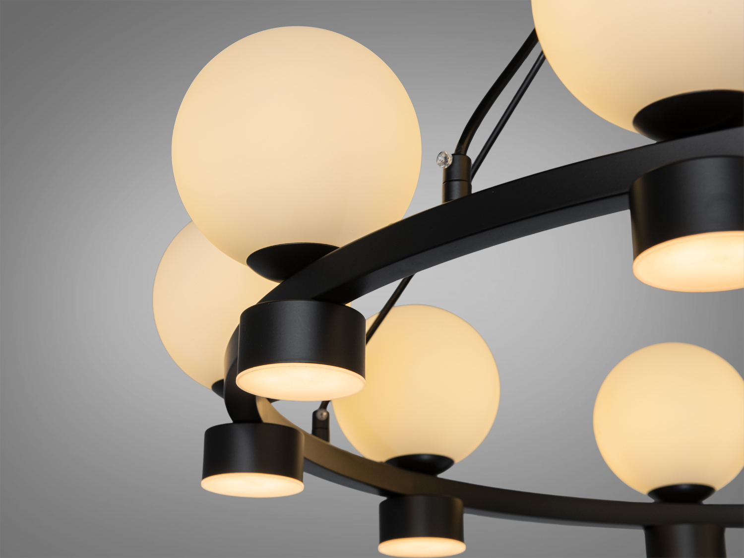 Деталь люстри з матовими круглими плафонами, що створюють м’яке розсіяне світло, підходить для сучасного інтер’єру.