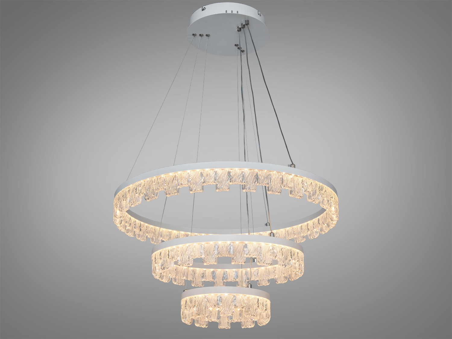 Підвісна люстра з трьома кільцями різного діаметра, прикрашена кришталевими підвісками, підходить для сучасного інтер′єру.
