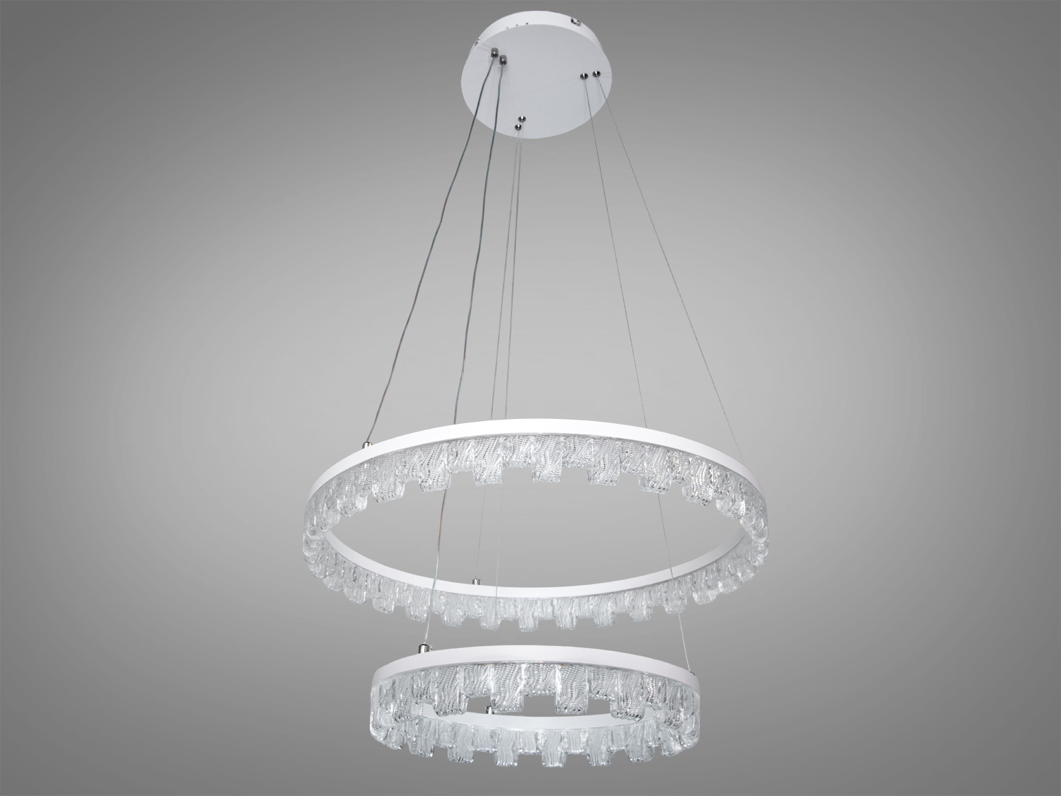 Підвісна люстра з двома кільцями, виготовлена з прозорого матеріалу, без увімкненого світла, підходить для мінімалістичних інтер’єрів.