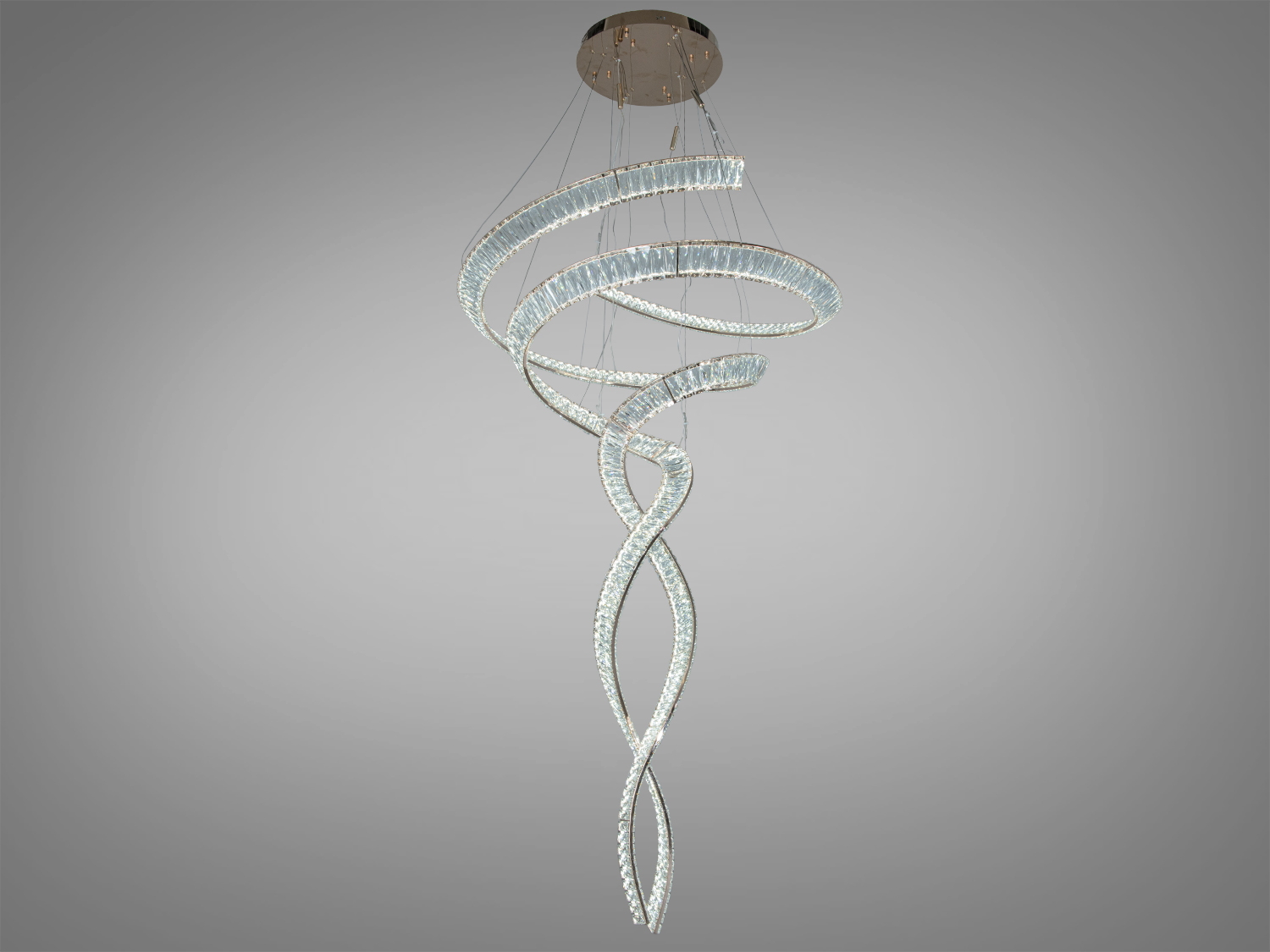 Спіральна люстра з прозорого матеріалу, ідеальна для високих стель. Випромінює холодне світло, підходить для мінімалістичного стилю.