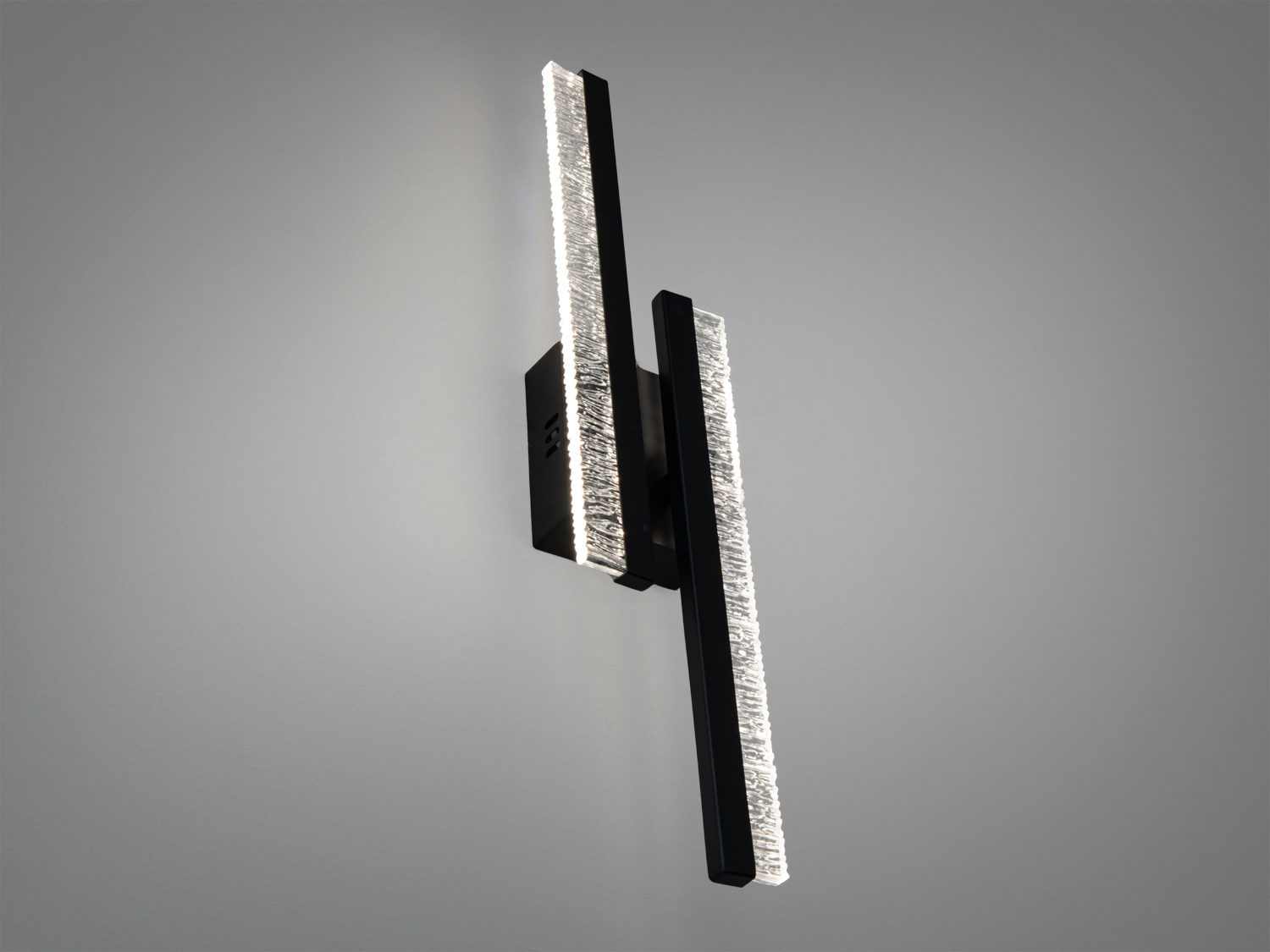 Настінний світильник з двома вертикальними світлодіодними панелями, що забезпечують яскраве освітлення. Чорний корпус з текстурованим склом.