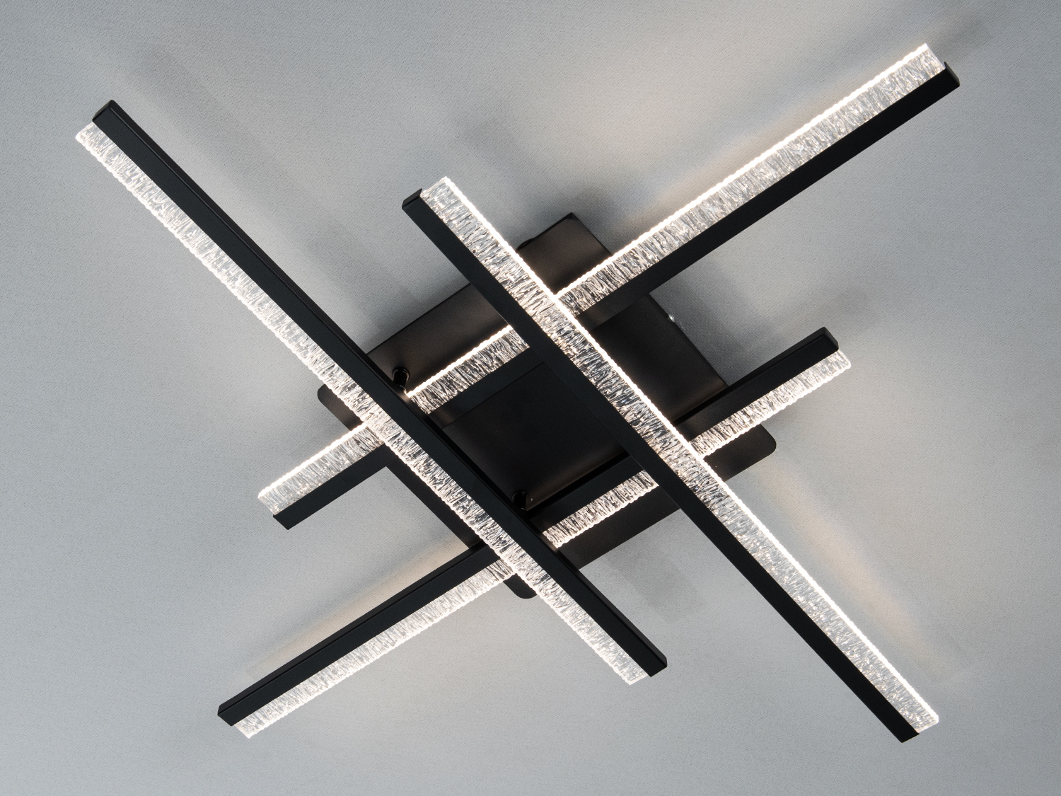 Світильник з перехресними металевими планками, що випромінюють холодне світло, підходить для сучасних інтер’єрів.