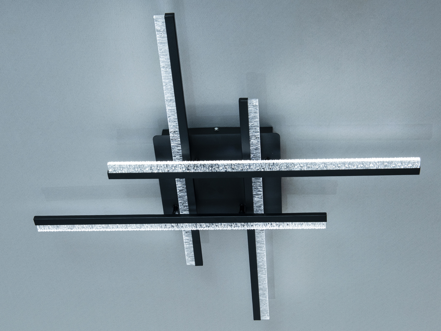 Стельовий світильник з перехресними планками, що випромінюють яскраве світло, створює сучасний акцент у приміщенні.