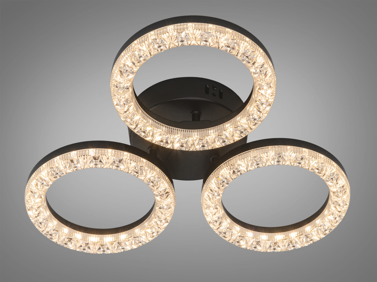 Три кільця з кристалами на чорній основі, що забезпечують тепле освітлення. Підходить для стельового монтажу в сучасних приміщеннях.