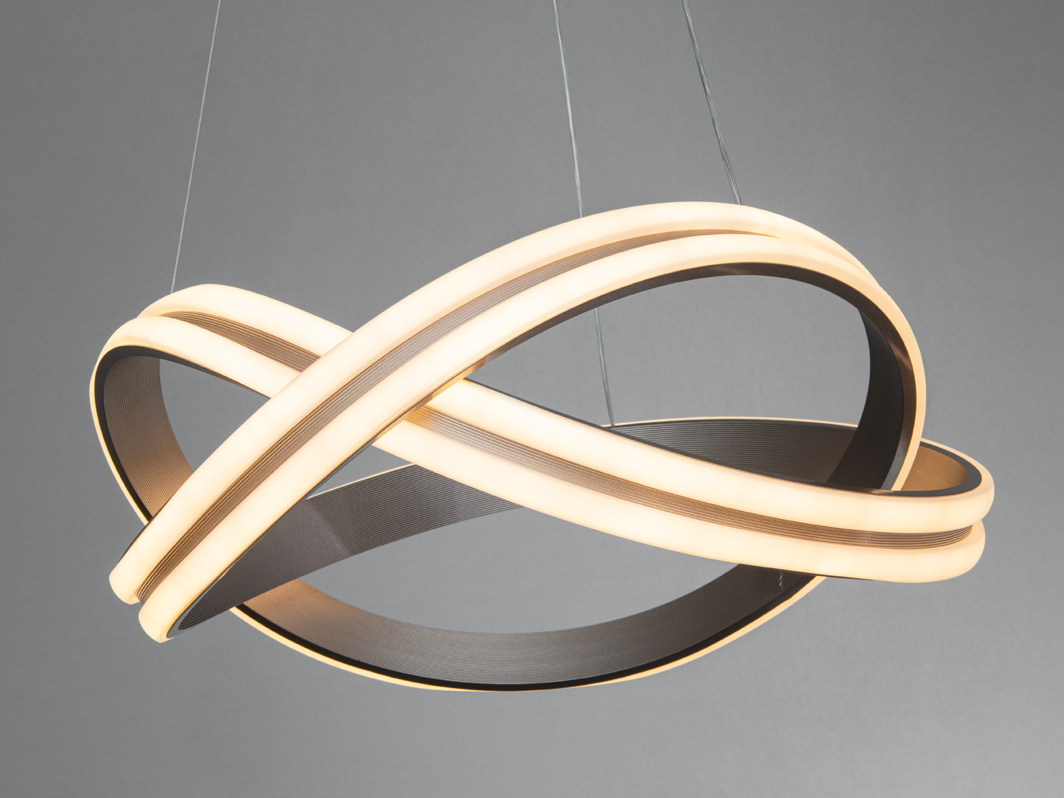 Підвісний світильник з теплим світлом, що підкреслює сучасний стиль. Переплетені кільця додають динаміки в освітлення.