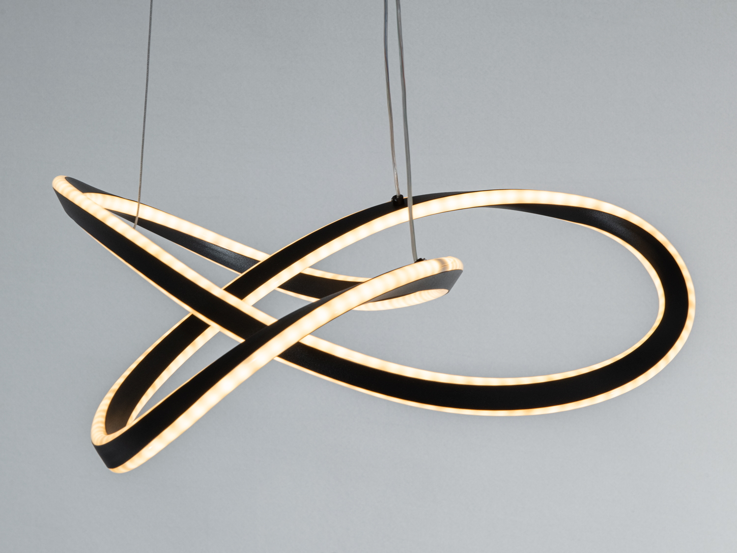 Лампа з переплетеними кільцями, що випромінюють тепле жовте світло. Ідеальний акцент для вітальні або спальні.