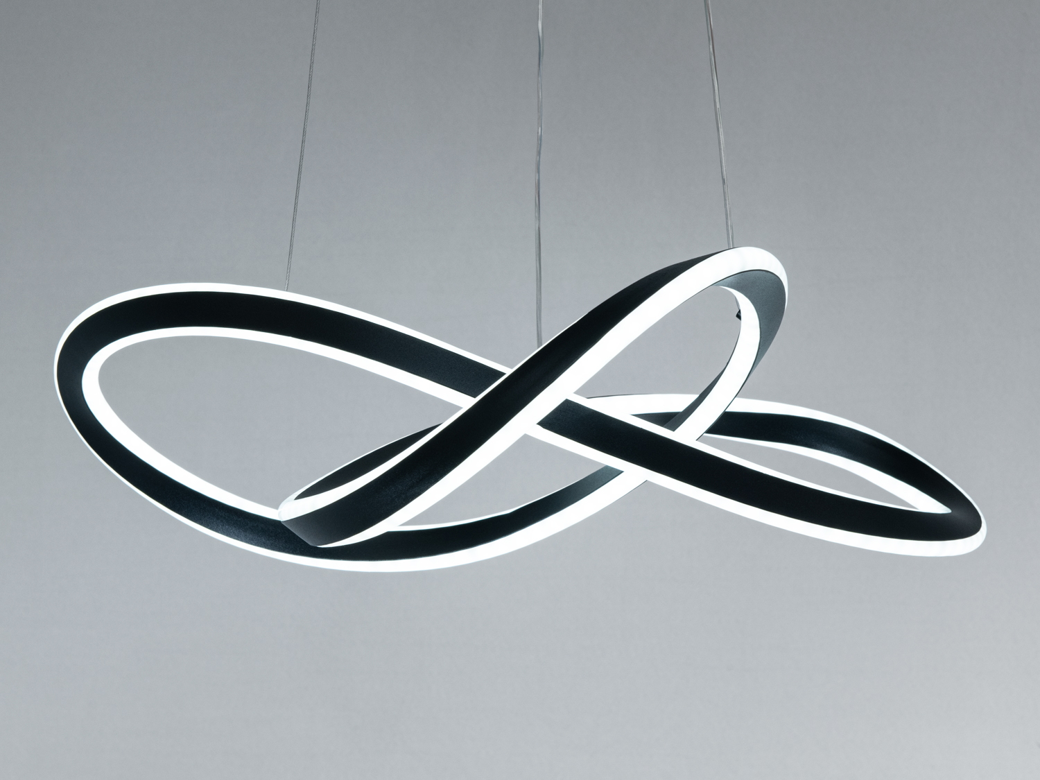 Дизайнерський світильник з плавними лініями, що створює яскраве біле освітлення. Підвісний монтаж для відкритих просторів.